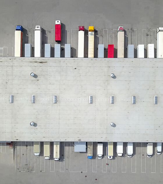 An aerial view of semitrucks parked at a truck loading doc 